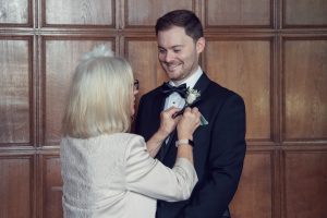 A woman helping a man buttoning a suit.